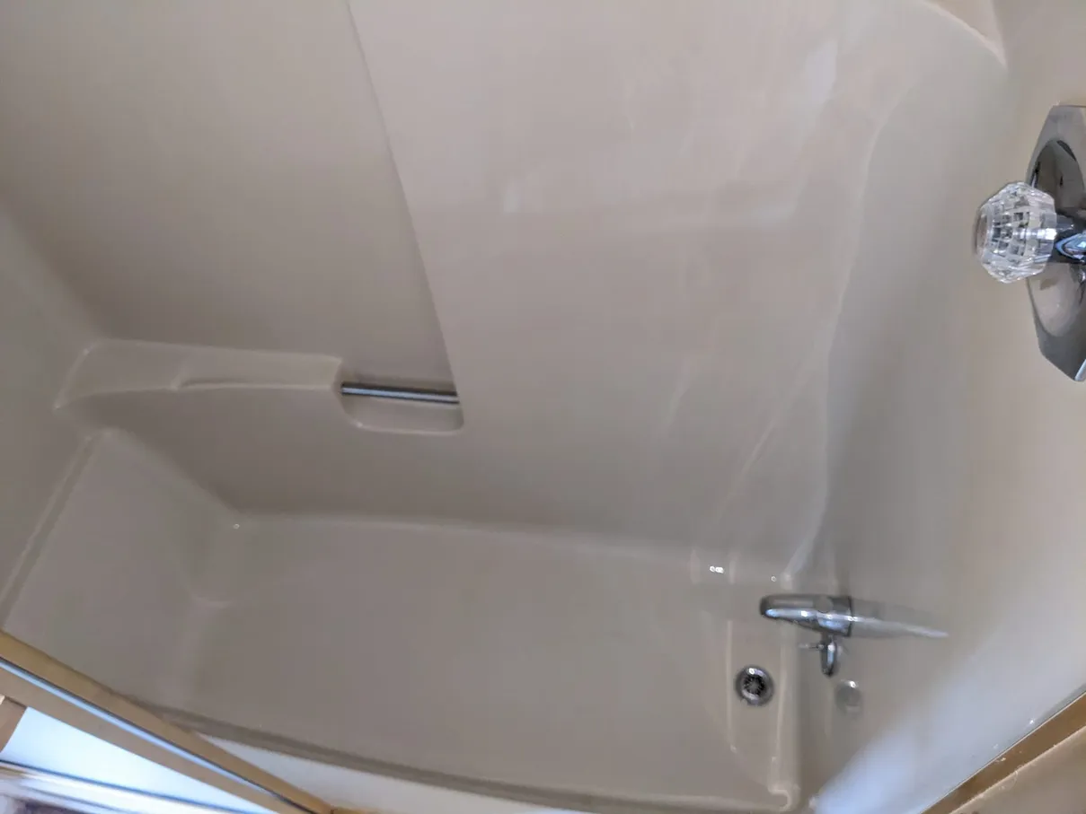 The same bathtub after cleaning, with a smooth, residue-free surround and polished fixtures.